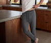 Person wearing gray sweatpants with a kitchen in the background